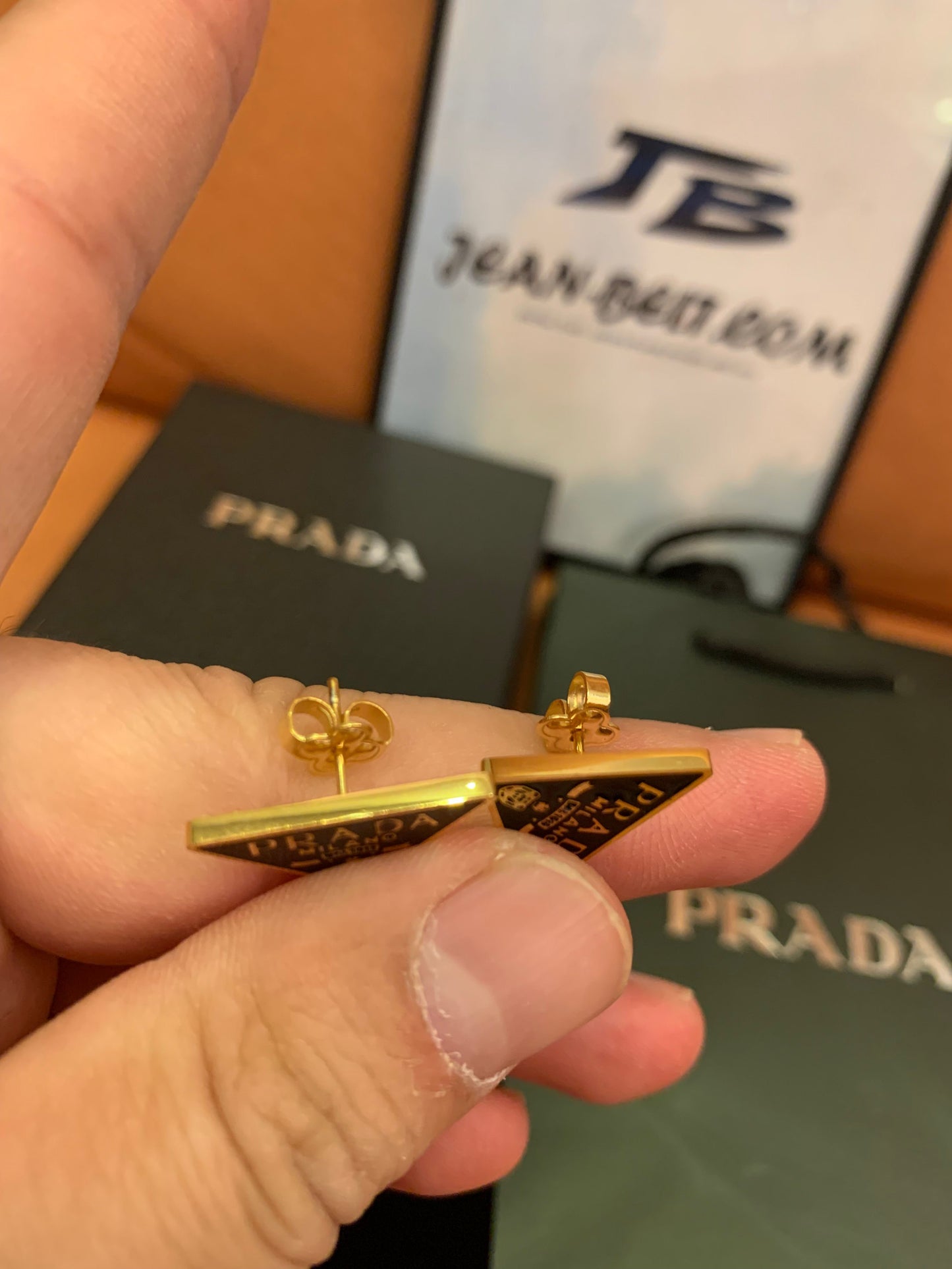 Prada Triangle logo stud earrings in black and gold