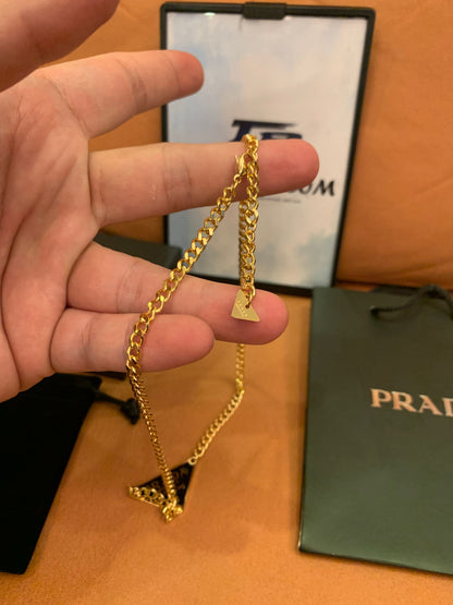 Prada Triangle logo pendant necklace in black and gold