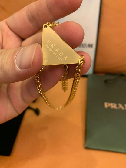 Prada Triangle logo pendant necklace in black and gold