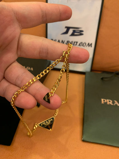 Prada Triangle logo pendant necklace in black and gold