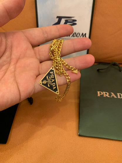 Prada Triangle logo pendant necklace in black and gold