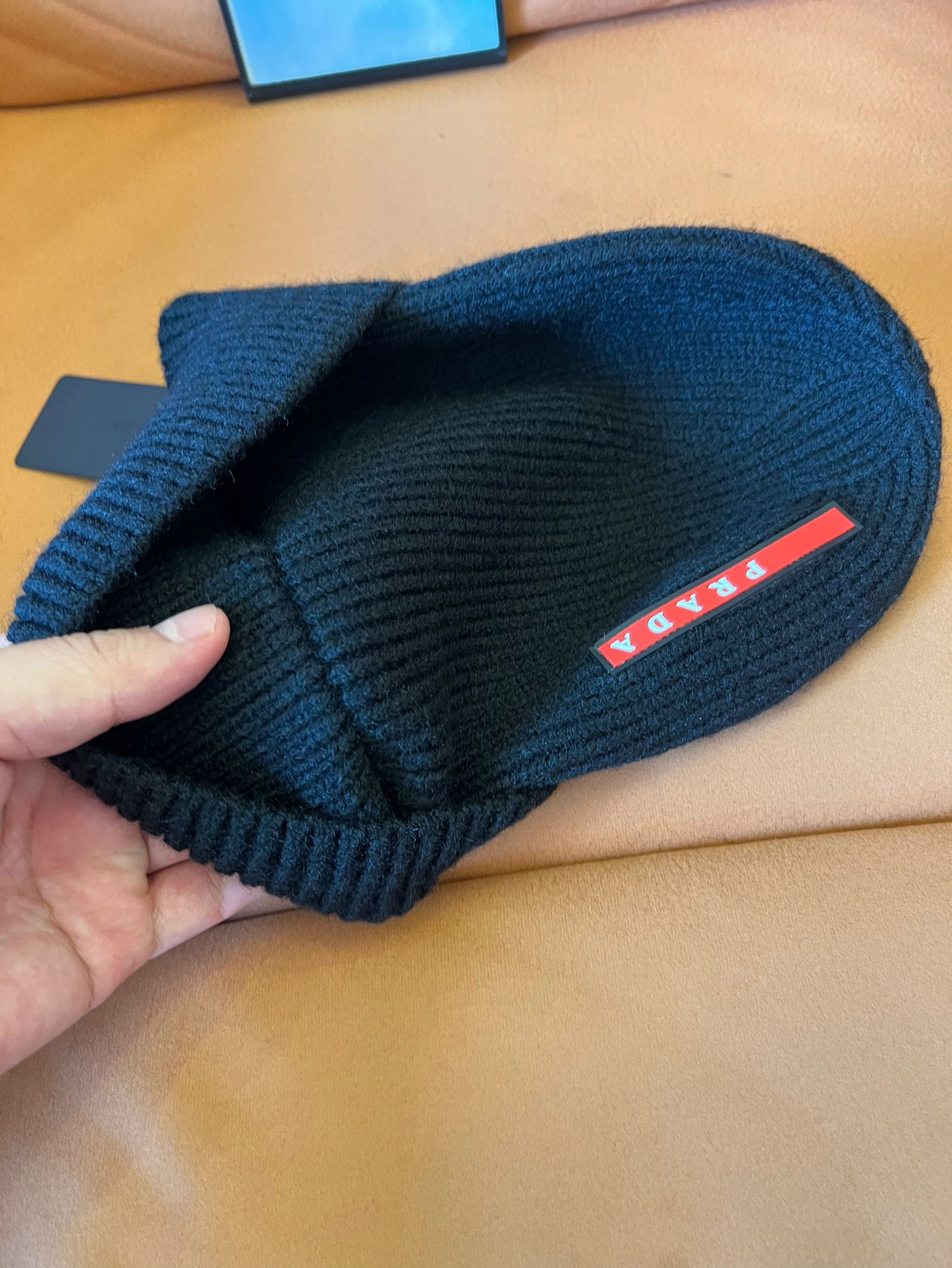 Prada black knitted wool beanie with signature red stripe logo