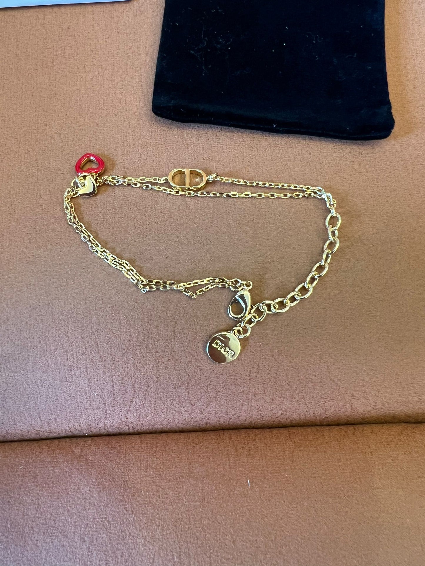 Dior gold chain bracelet with iconic CD and heart charms