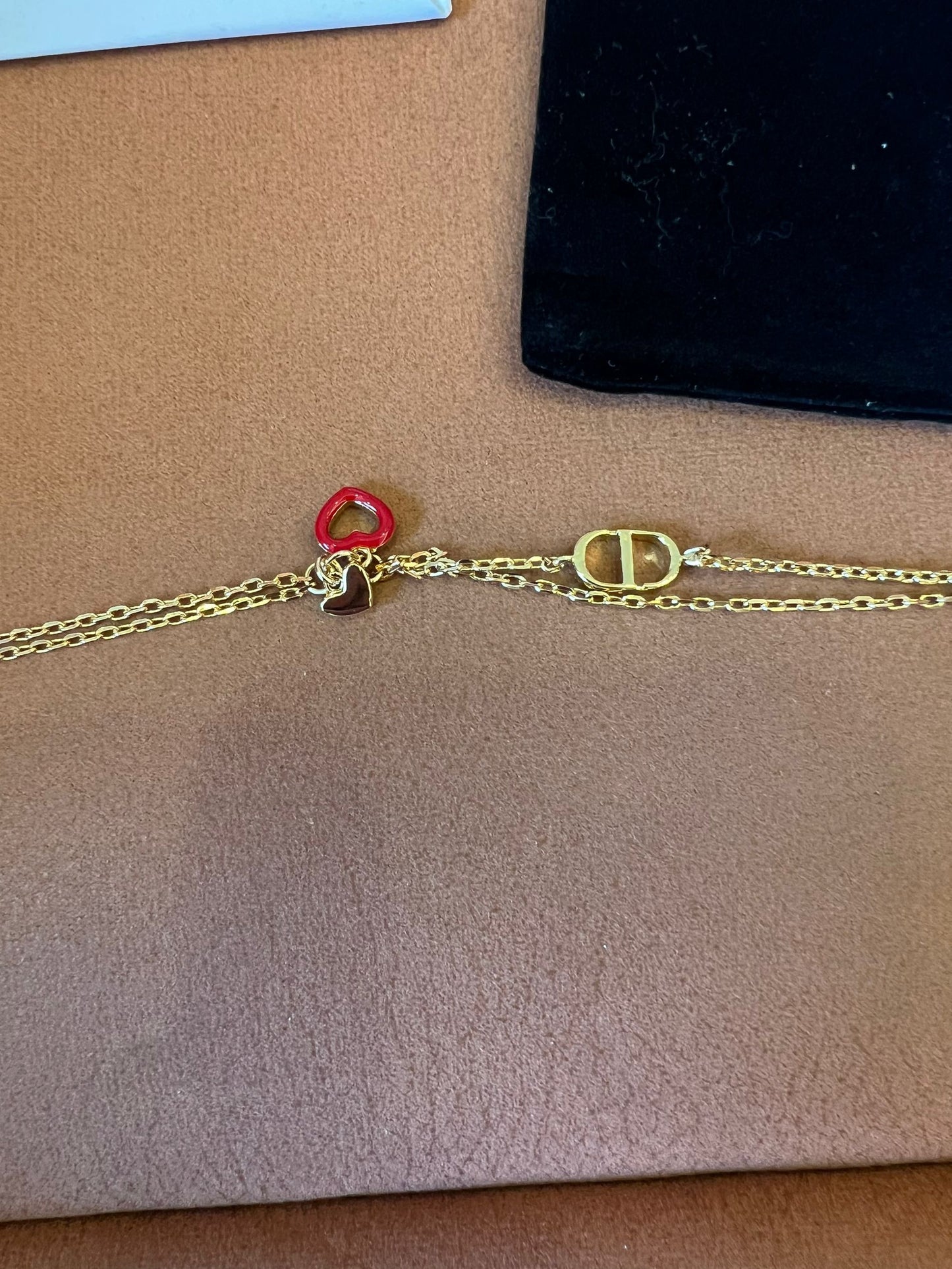 Dior gold chain bracelet with iconic CD and heart charms