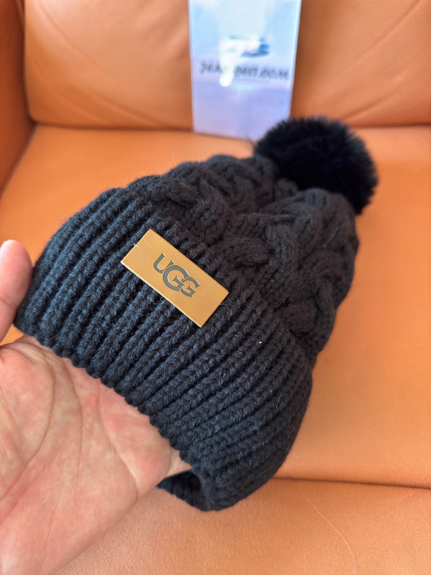 UGG black cable knit beanie with pom-pom and logo plaque