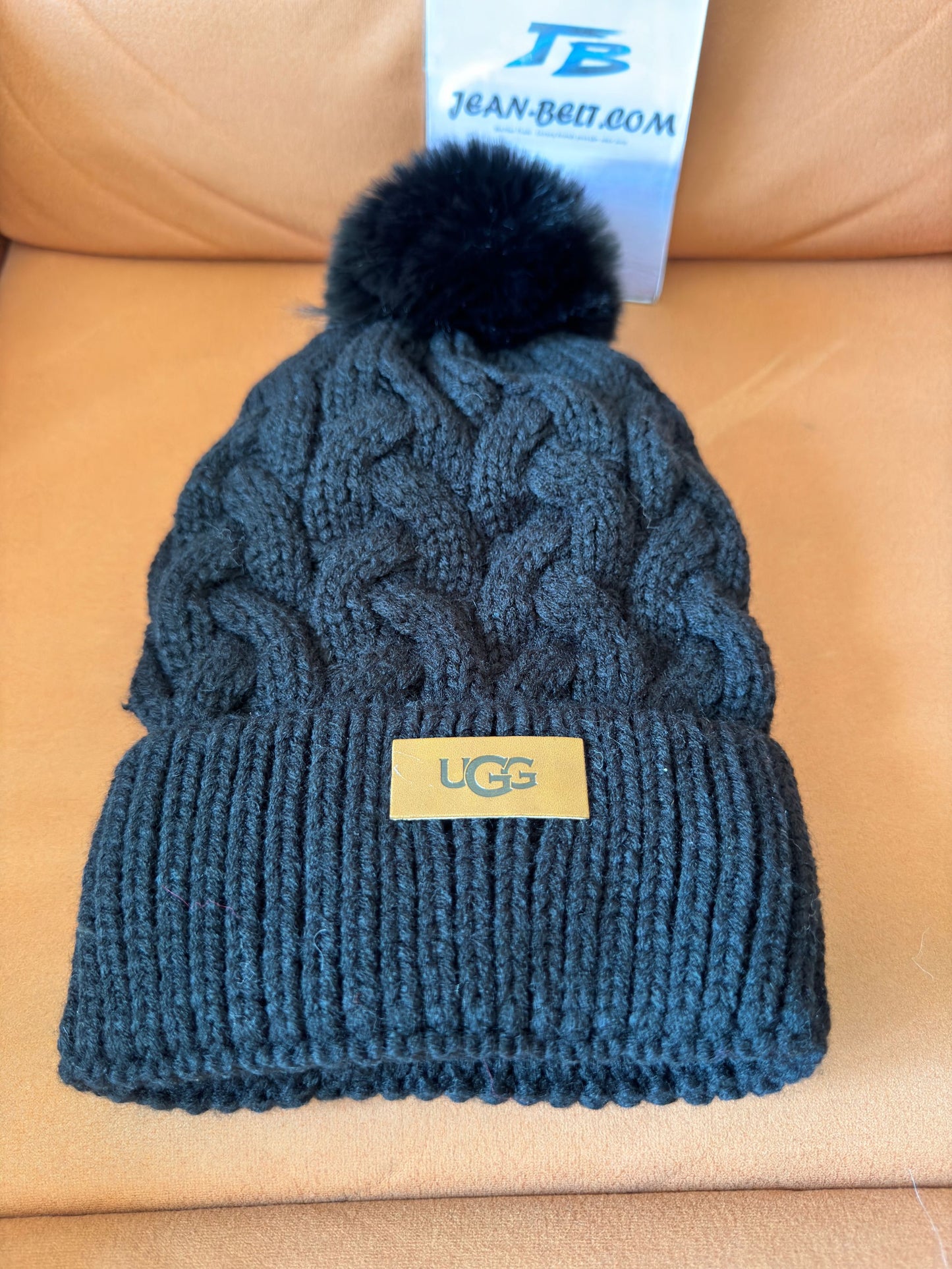 UGG black cable knit beanie with pom-pom and logo plaque